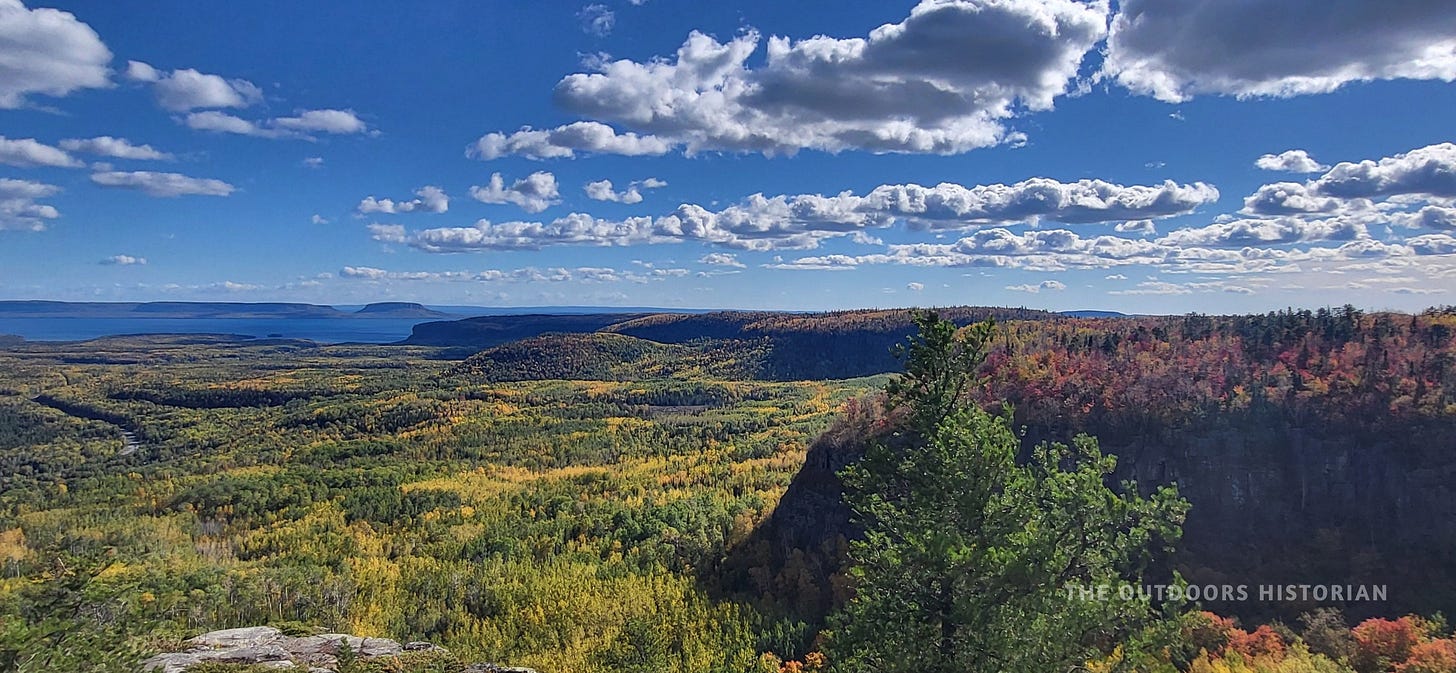 A view from the rocky, uneven top of Mount McKay, showing sparse vegetation and the open sky.