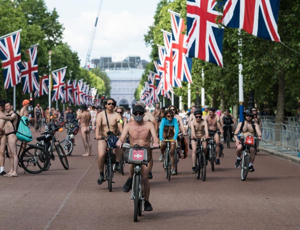 A group of nude cyclists rides along The Mall in London, surrounded by rows of Union Jack flags, participating in the World Naked Bike Ride to protest car culture and celebrate body freedom. A group of nude cyclists rides along The Mall in London, surrounded by rows of Union Jack flags, participating in the World Naked Bike Ride to protest car culture and celebrate body freedom.