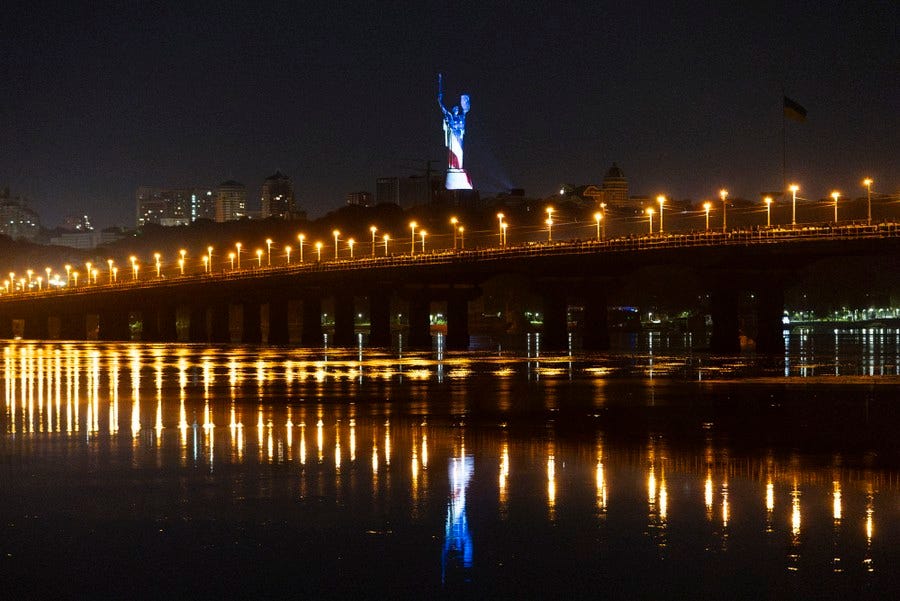 A very tall monument is illuminated in the colors of an American flag. A very tall monument is illuminated in the colors of an American flag.