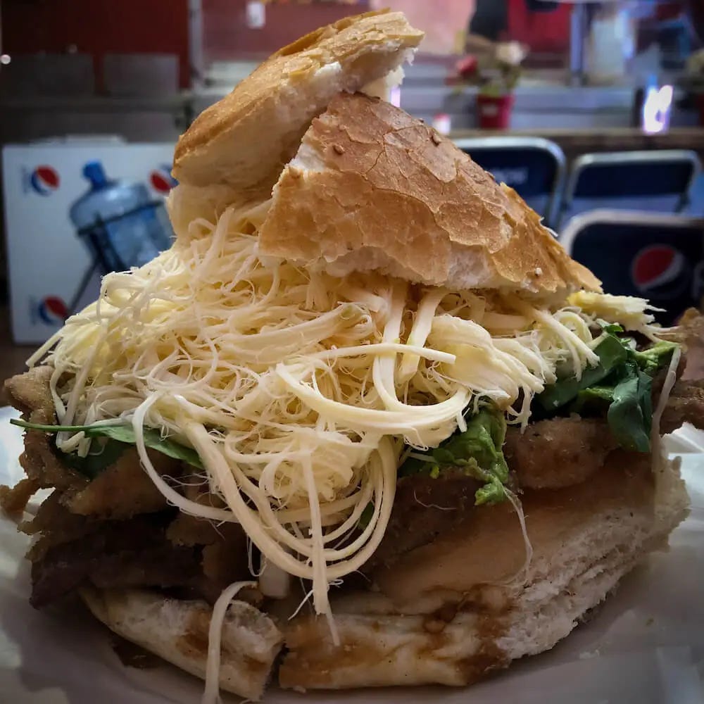 A bread roll stuffed with meat and stringy cheese