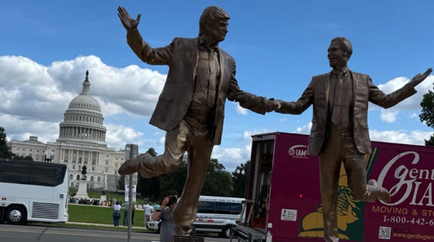 A statue of two men in suits

AI-generated content may be incorrect.