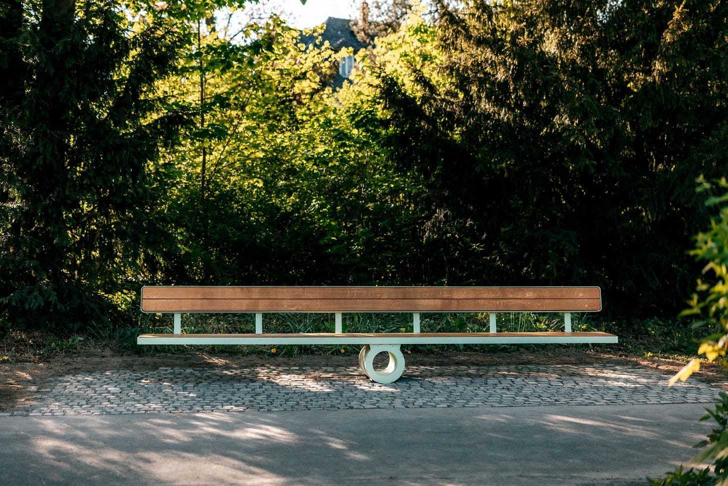 a wooden bench with a round base in the center