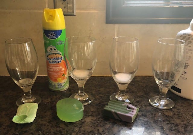A group of glasses and soap on a counter

Description automatically generated