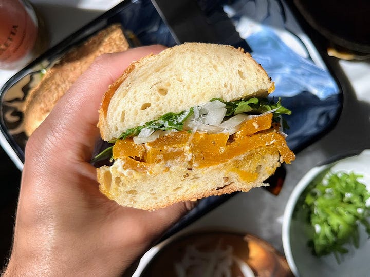 Sandwich being assembled, hand holding finished sandwich