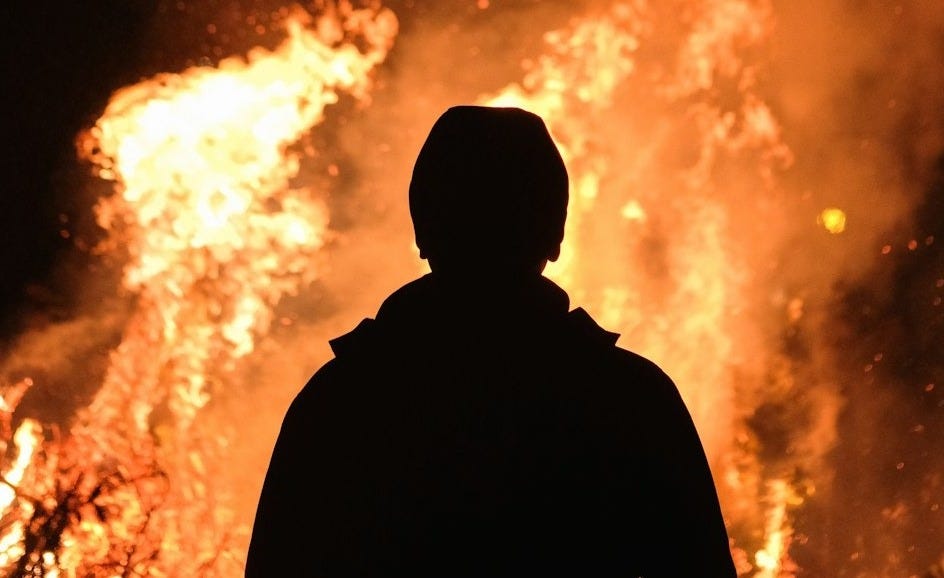 person standing in front of fire person standing in front of fire