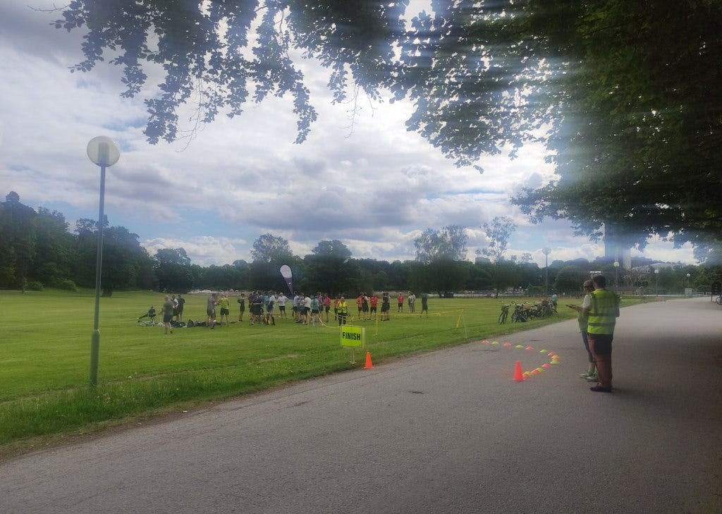 Cones mark the finish, heading off the path and onto the grass, with plenty of room for finishers to mill about and a few bikes parked by the finish line.