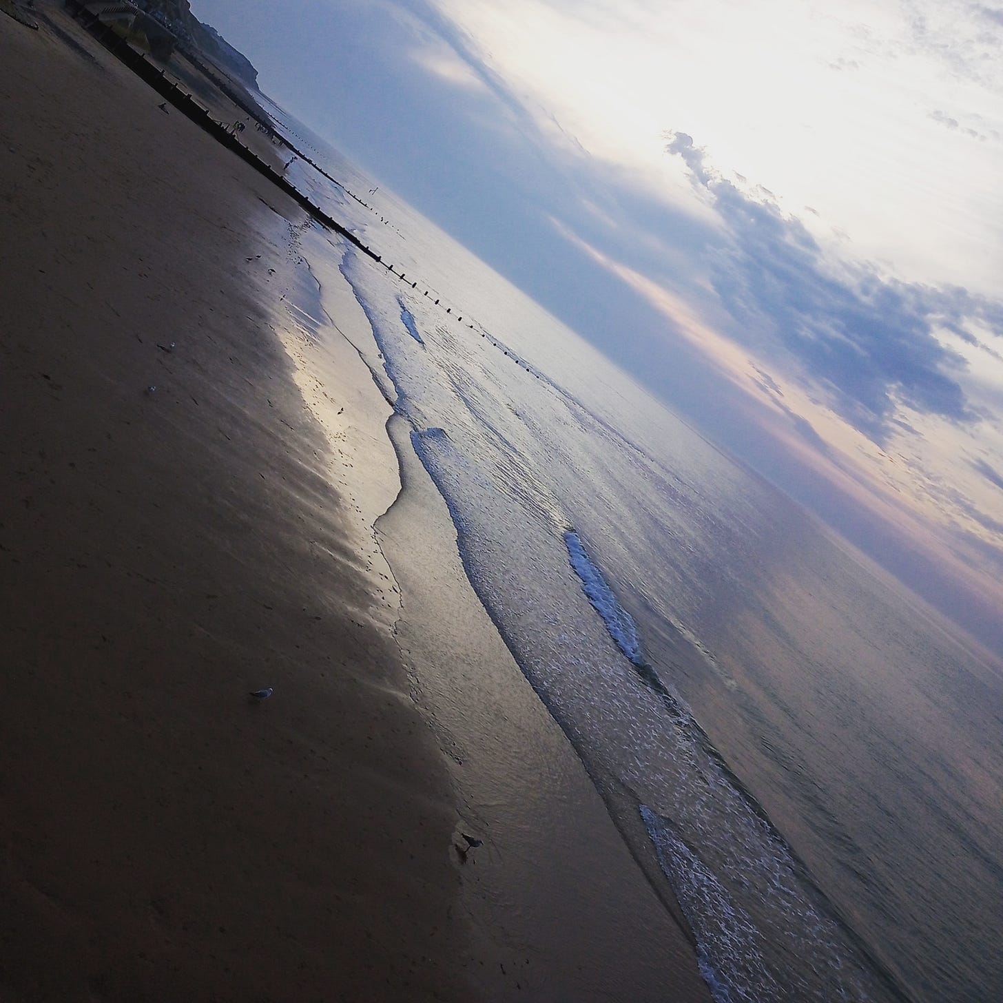 Summer evening sky at Cromer beach with cliffs in background