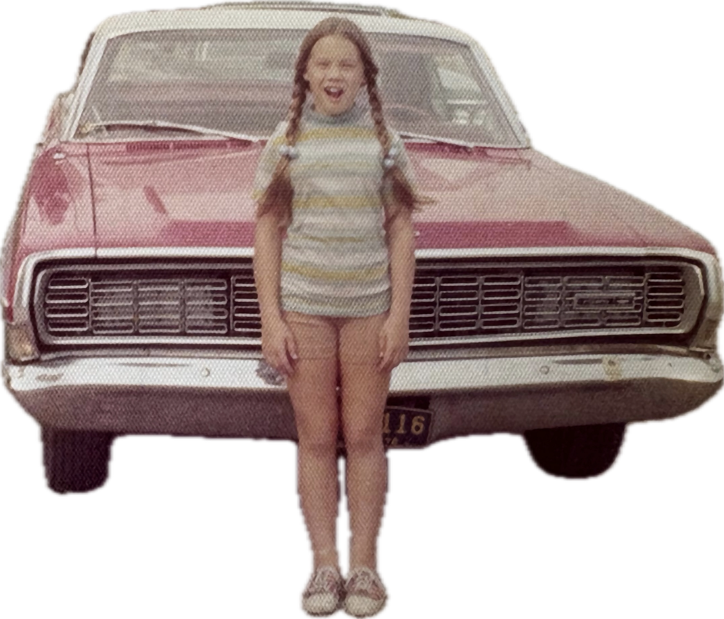 girl in pigtails standing in front of a red car circa 1972