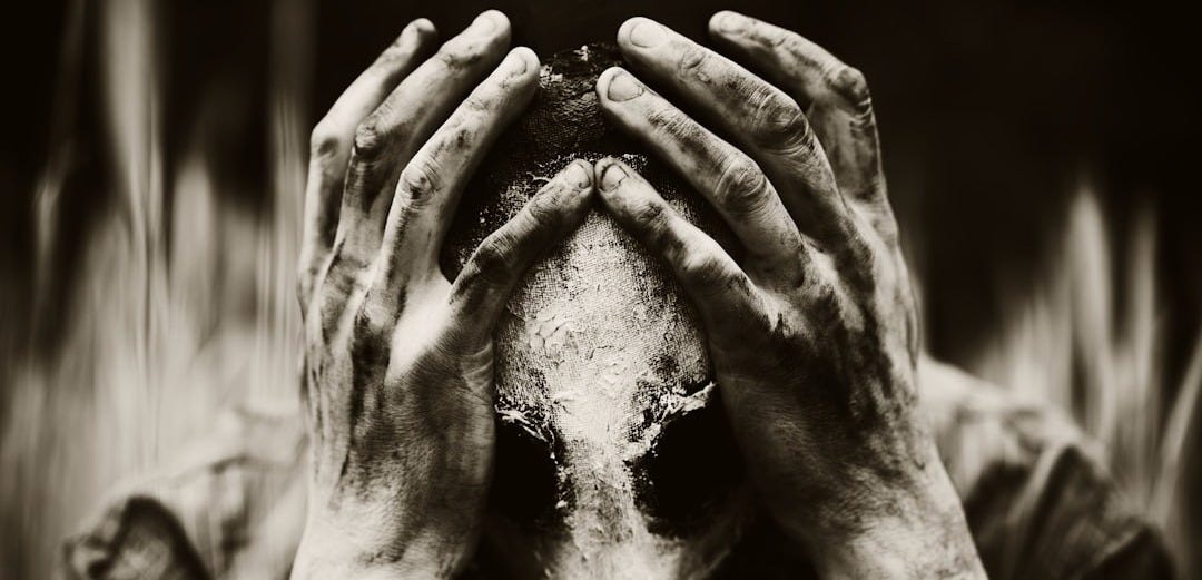 a person covering their face with their hands