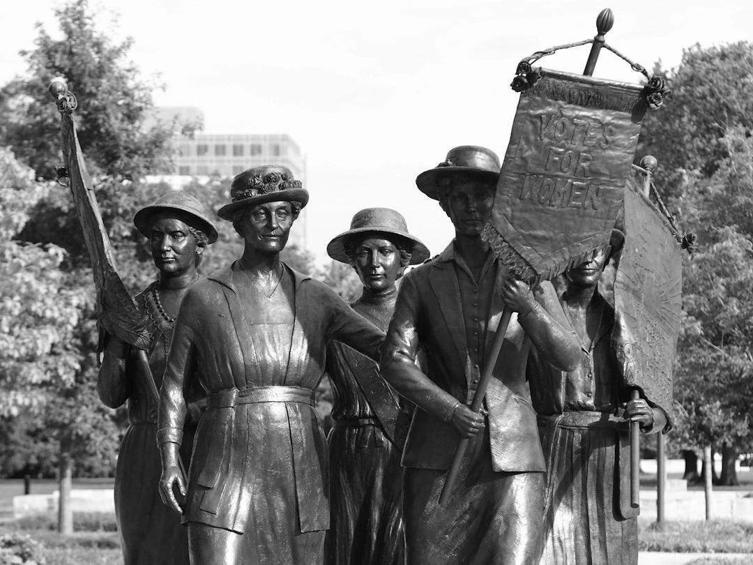 a group of people standing next to a statue