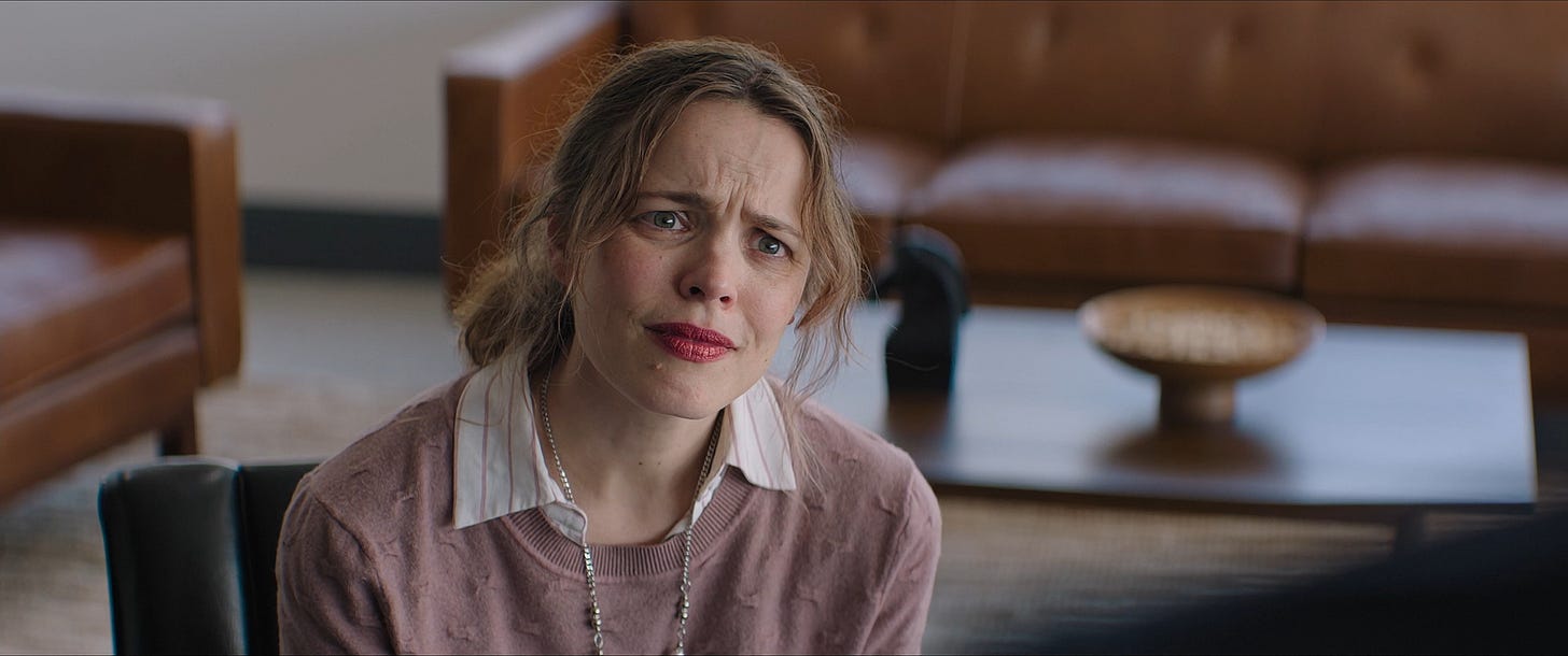 A still from the movie Send Help, showing Rachel McAdams with slightly frizzy hair and a slightly frumpy sweater, and that's supposed to make her ugly, I guess?