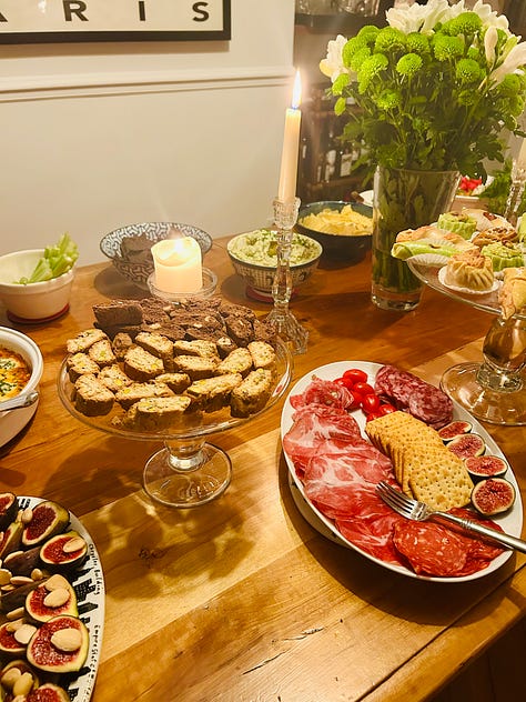bottles of French wine from two tastings. Wines of Burgundy and the Loire Valley. Plates of appetizers on a wooden table.