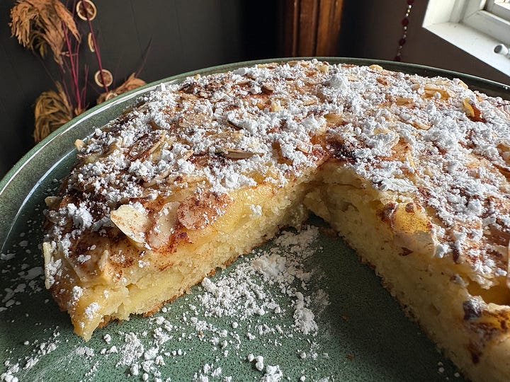 Left image of an outdoor table, featuring a latte with pumpkin latte art, a muffin, and a writing notebook with plants all over the cover. Right image of a cake covered in powdered sugar with a large slice missing.