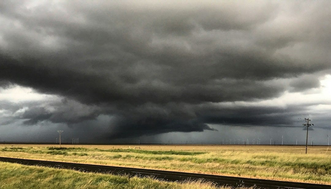 green grass field under gray clouds green grass field under gray clouds