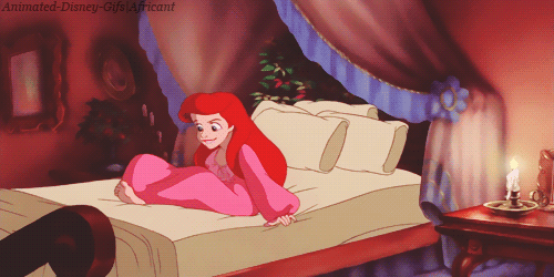 This may contain: the little mermaid is sitting on her bed