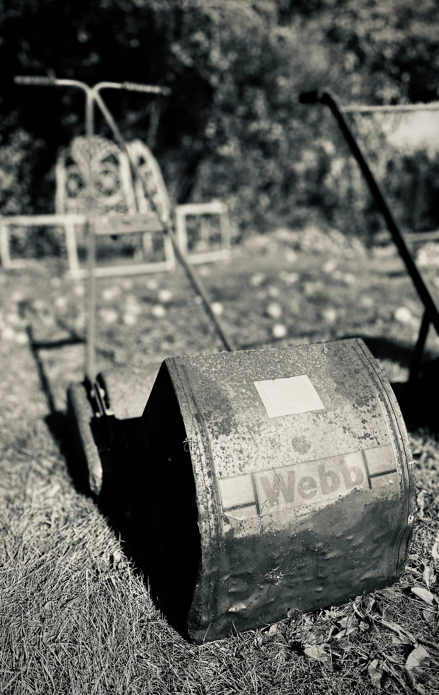 A black and white image of a Webb mower in a garden setting