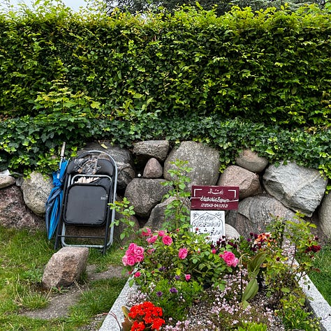 Tove Ditlevsen's simple stone, a battered folding chair leans next to an Arabic grave planted with flowers; Hells Angel gravestone with candle holder and plants