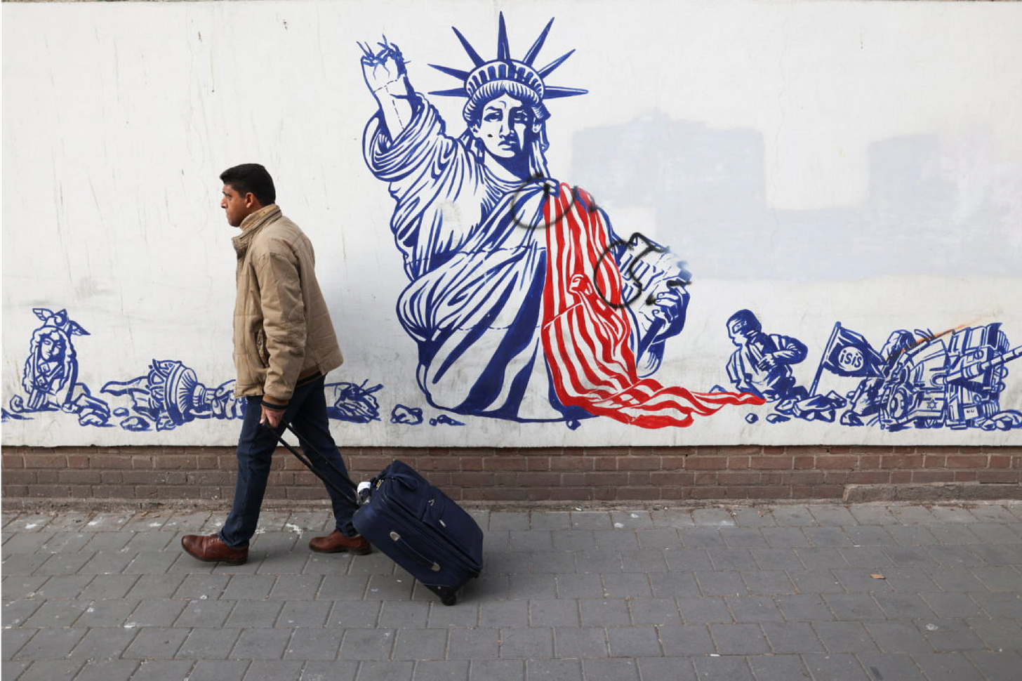 Left: An Iranian man walks past an anti-U.S. mural on the wall of former U.S. Embassy in Tehran, Iran January 25, 2023. Majid Asgaripour/WANA (West Asia News Agency)/Handout via REUTERS.