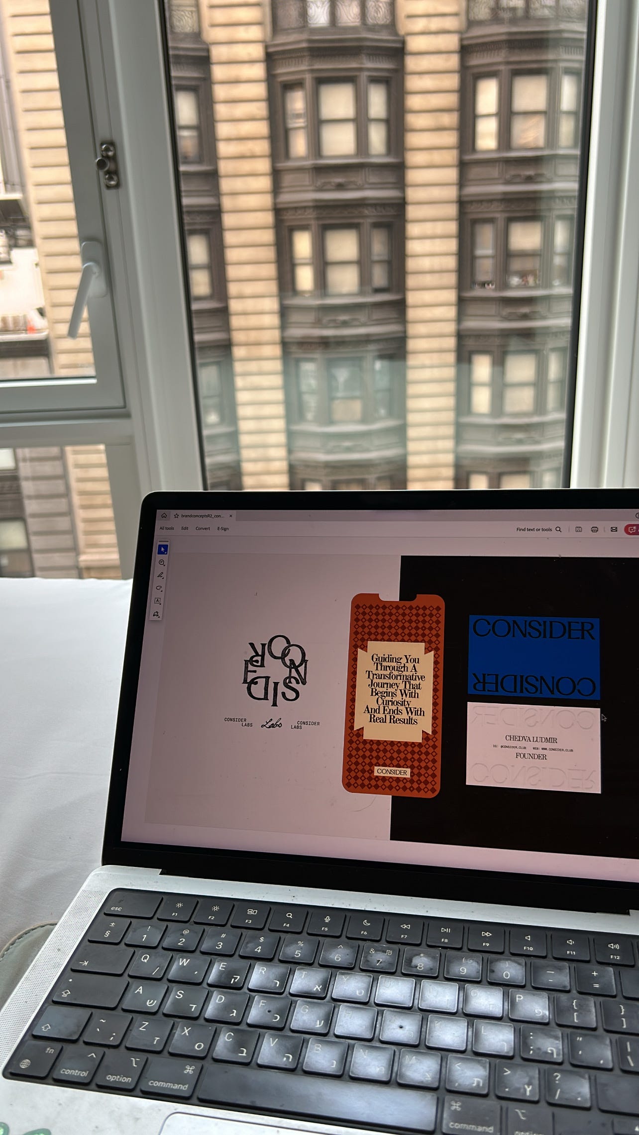 laptop with consider branding with NYC architecture behind it