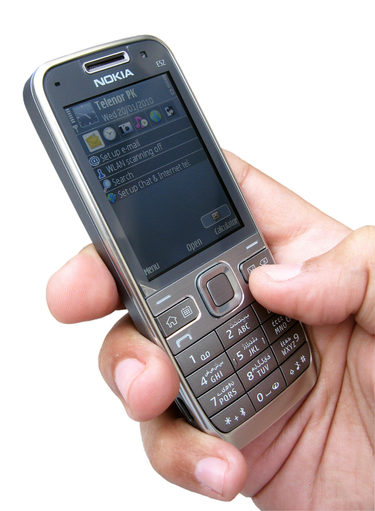 Nokia E52 phone with a physical keyboard in a person's hand, phone screen showing the desktop with email icon in focus