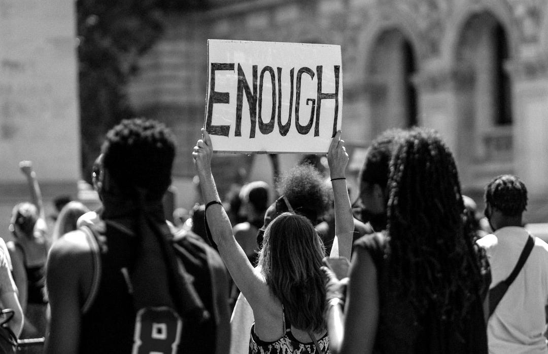 people holding a signage during daytime people holding a signage during daytime