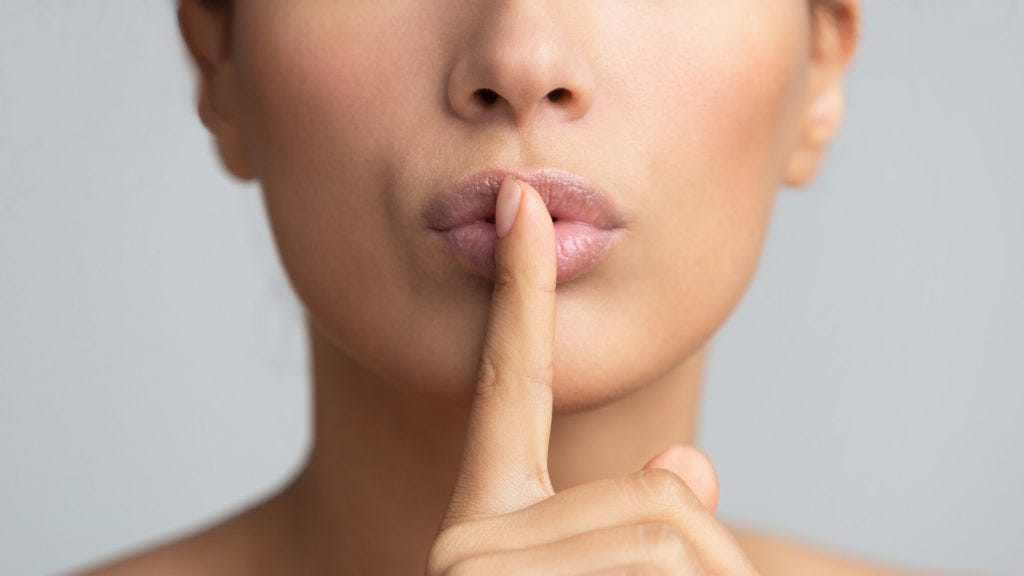 Women's secret. Woman holding finger on lips Women's secret. Woman holding finger on lips
