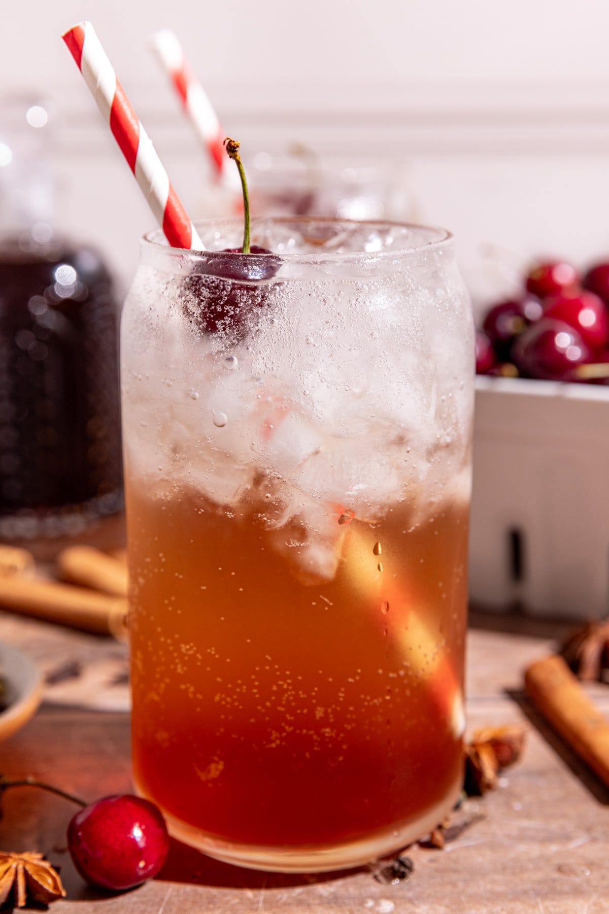 A soda glass of homemade Dr. Pepper with a cherry garnish and red & white striped straw. A soda glass of homemade Dr. Pepper with a cherry garnish and red & white striped straw.