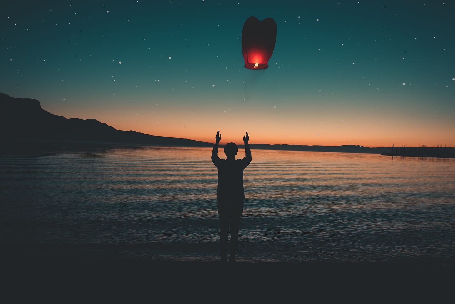 Silhouette releasing a floating lantern by a peaceful lake at sunset, creating a serene and magical atmosphere representing what it's like to let go of what you're carrying as a long-term expat or migrant abroad with Kay Fabella at Edgewalkers Collective Silhouette releasing a floating lantern by a peaceful lake at sunset, creating a serene and magical atmosphere representing what it's like to let go of what you're carrying as a long-term expat or migrant abroad with Kay Fabella at Edgewalkers Collective