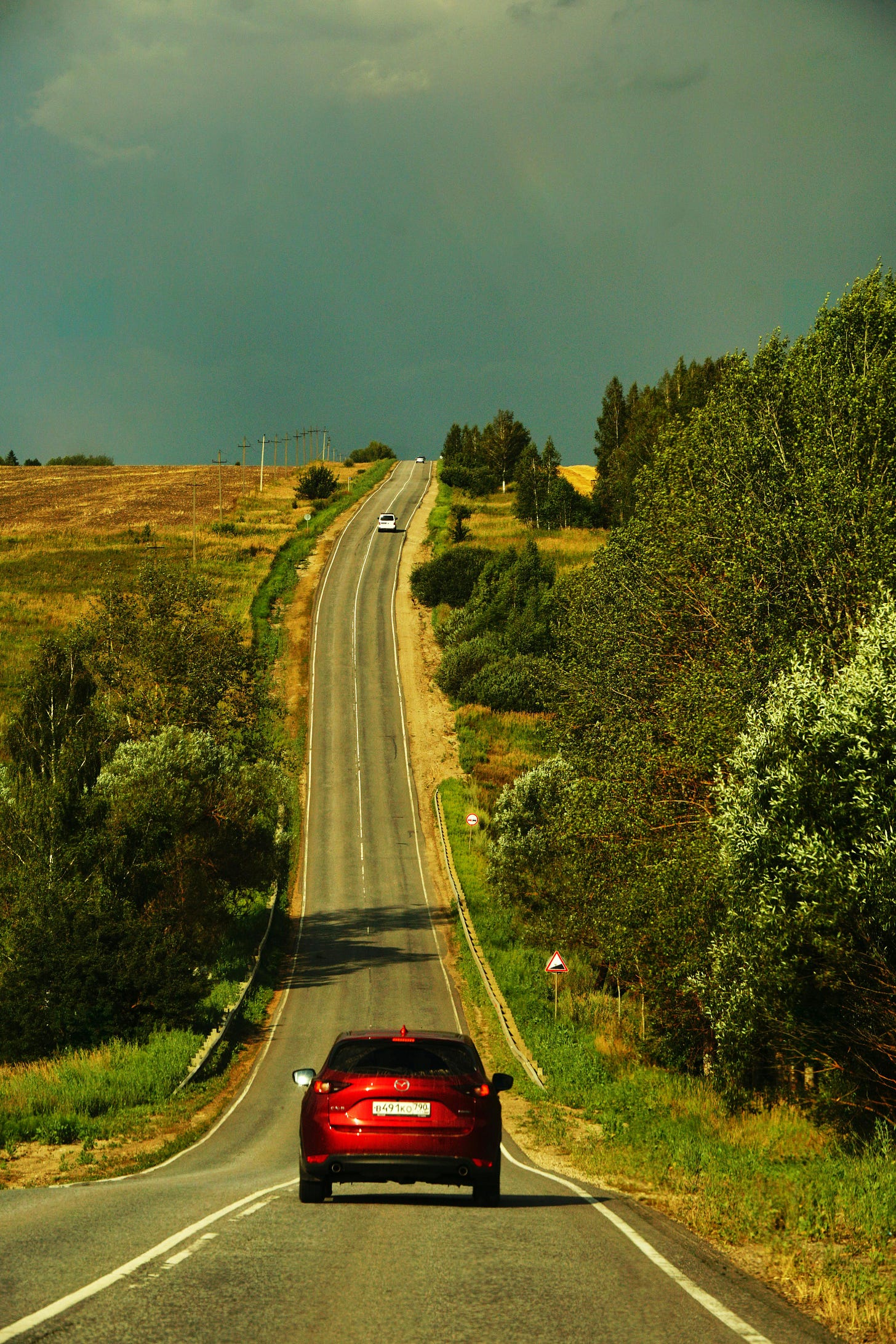Scenic Countryside Road with Red Car at Sunset · Free Stock Photo