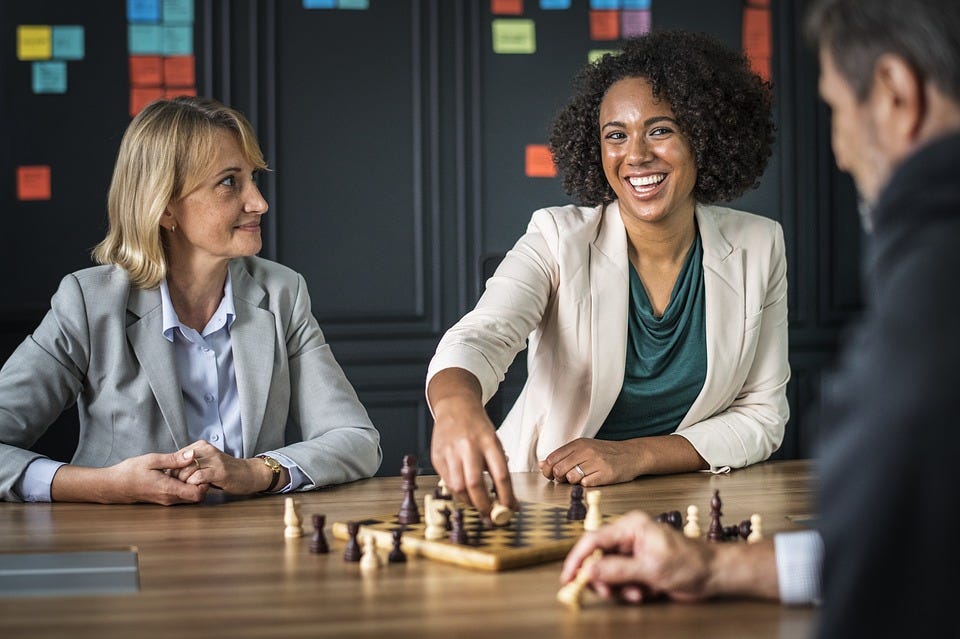Several employees are talking across a table from each other