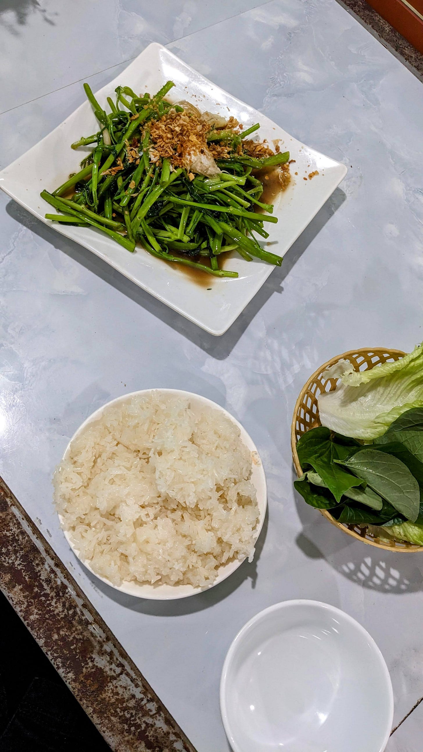 plate of cooked morning glory greens with fried garlic