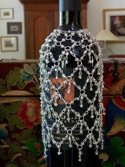 This may contain: a bottle that is sitting on a table in front of a wall with pictures behind it This may contain: a bottle that is sitting on a table in front of a wall with pictures behind it