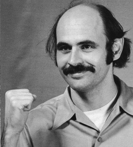 Karl Armstrong with fist raised, one of four men responsible for the 1970 bombing of Sterling Hall. Photograph was taken in prison. Armstrong was apprehended in 1972 in Canada.
Early on August 24th, 1970, a van loaded with six barrels of explosives blew up just outside the East Wing of Sterling Hall at the University of Wisconsin campus in Madison. The bombing was carried out by four men in protest of America's involvement in the Vietnam War.
The bombing was directed against the Mathematics Research Center, a U.S.-Army-funded facility, which was located in the East Wing of Sterling Hall along with the physics and astronomy departments. "Army Math," as it was known, was despised by many antiwar activists who felt the center was contributing to the death and destruction in Southeast Asia through its research and had no place on a public university campus. Karl Armstrong with fist raised, one of four men responsible for the 1970 bombing of Sterling Hall. Photograph was taken in prison. Armstrong was apprehended in 1972 in Canada.
Early on August 24th, 1970, a van loaded with six barrels of explosives blew up just outside the East Wing of Sterling Hall at the University of Wisconsin campus in Madison. The bombing was carried out by four men in protest of America's involvement in the Vietnam War.
The bombing was directed against the Mathematics Research Center, a U.S.-Army-funded facility, which was located in the East Wing of Sterling Hall along with the physics and astronomy departments. "Army Math," as it was known, was despised by many antiwar activists who felt the center was contributing to the death and destruction in Southeast Asia through its research and had no place on a public university campus.