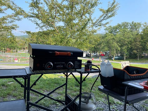 A blackstone griddle, cooking various meals, and a fire ring with marshmallows and a chocolate center