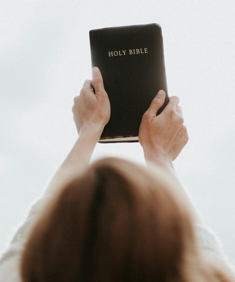 person holding Holy Bible