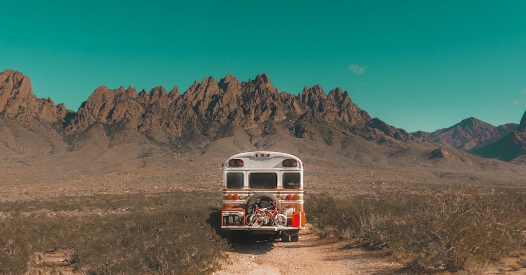 white and red bus near mountain white and red bus near mountain