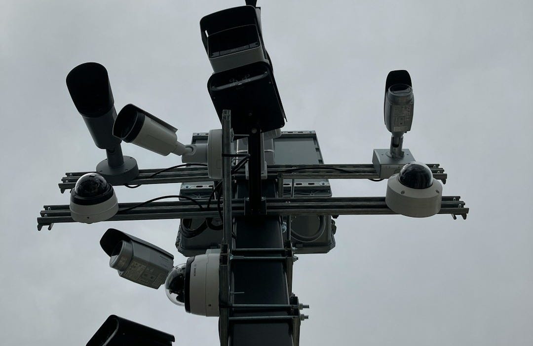 a traffic light with multiple cameras attached to it