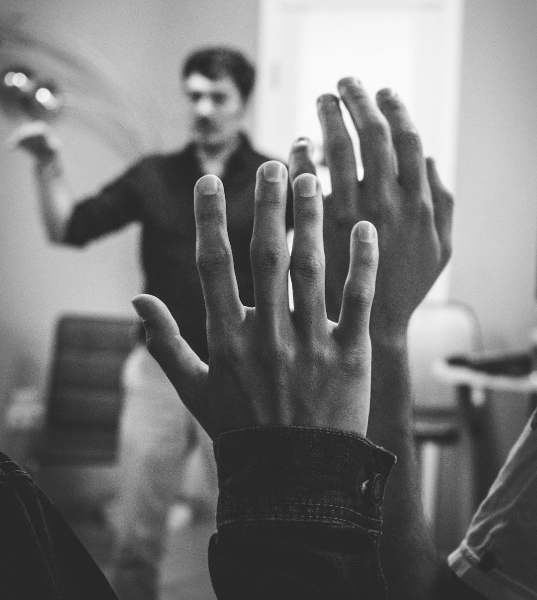 grayscale photography of two people raising their hands grayscale photography of two people raising their hands