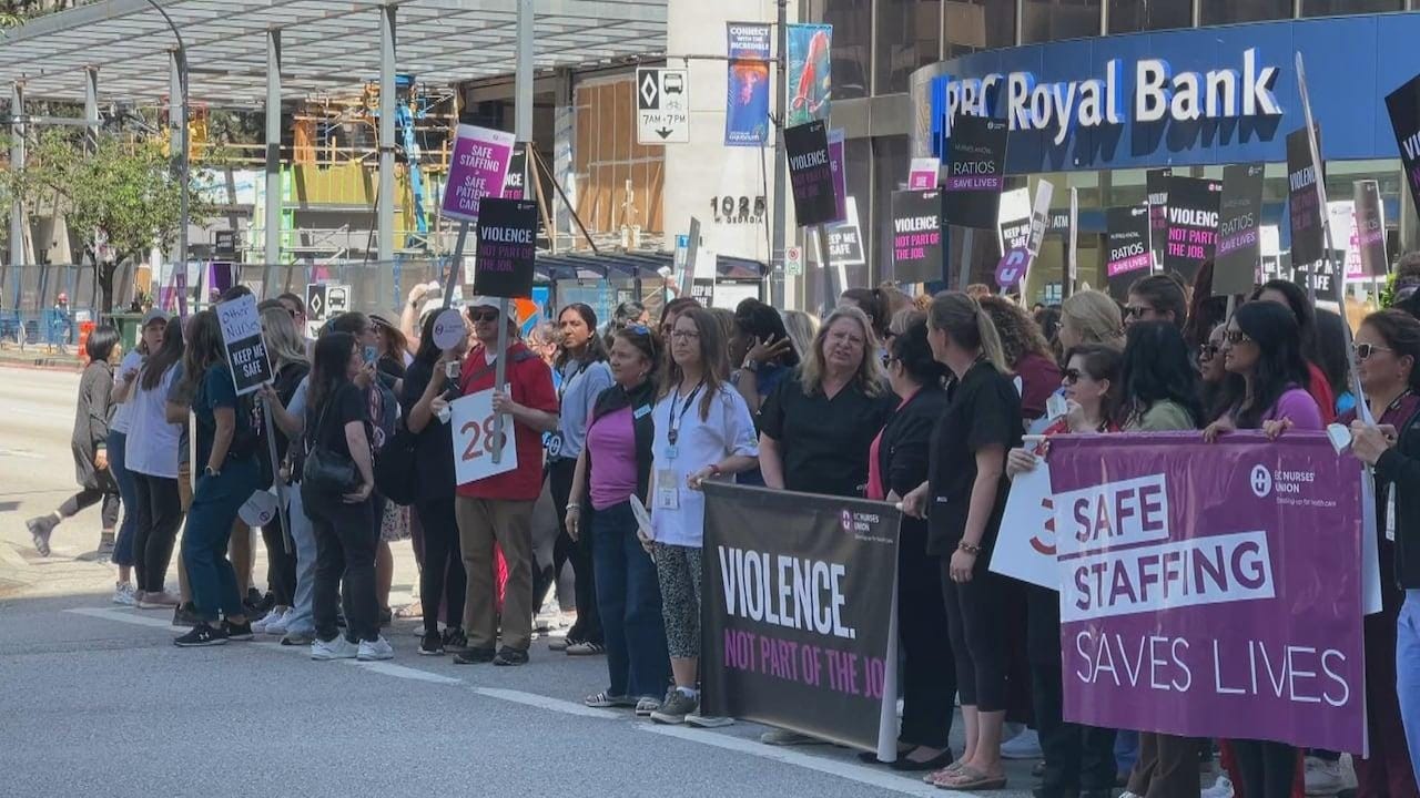 People hold signs reading safe staffing saves lives and violence not part of the job. People hold signs reading safe staffing saves lives and violence not part of the job.