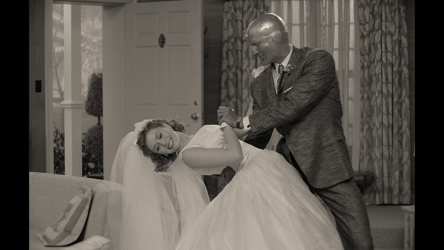Image of Wanda in wedding dress being dipped by Vision who is wearing a 3-piece suit. Black and white image Image of Wanda in wedding dress being dipped by Vision who is wearing a 3-piece suit. Black and white image