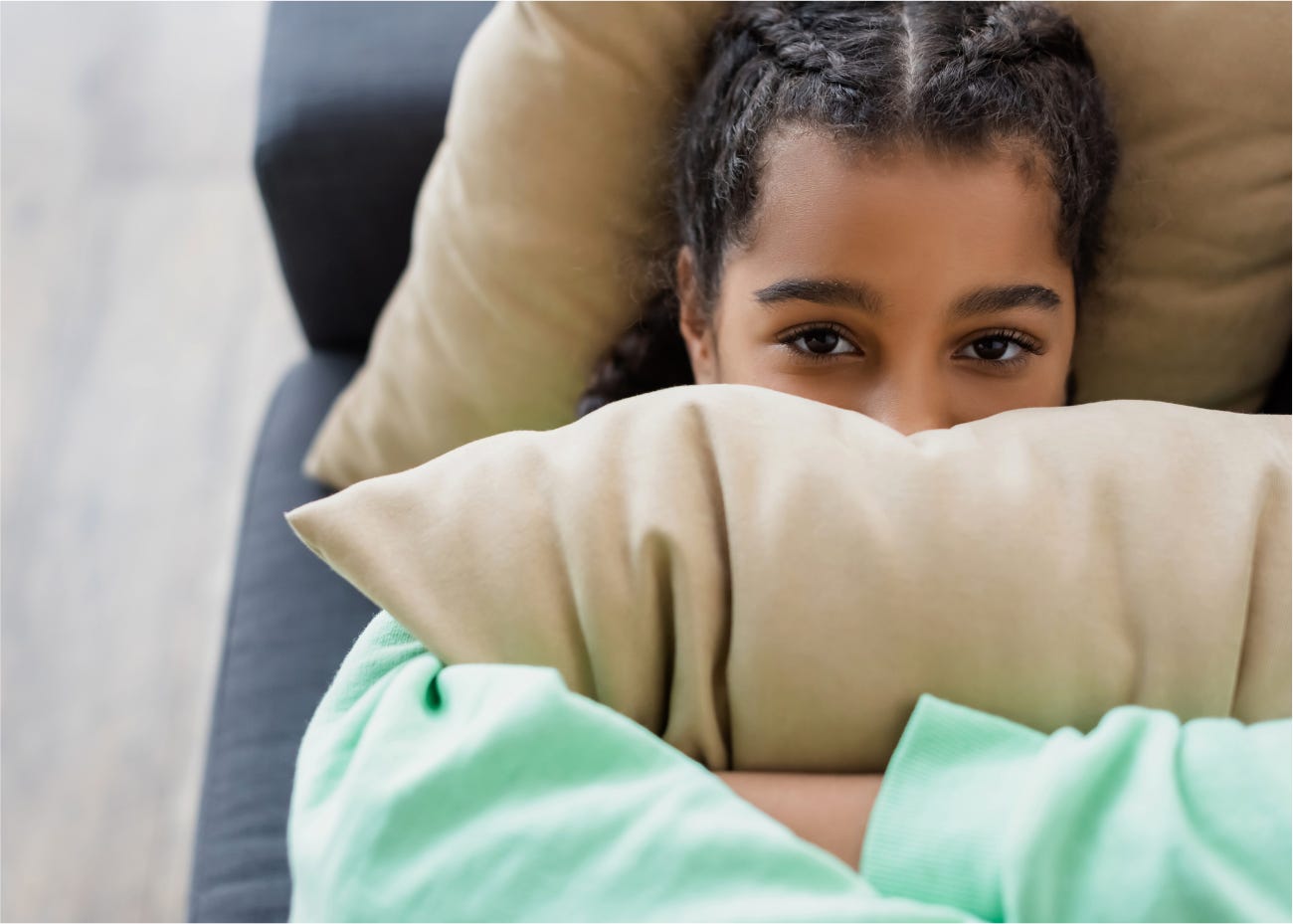 child holding a pillow over their mouth