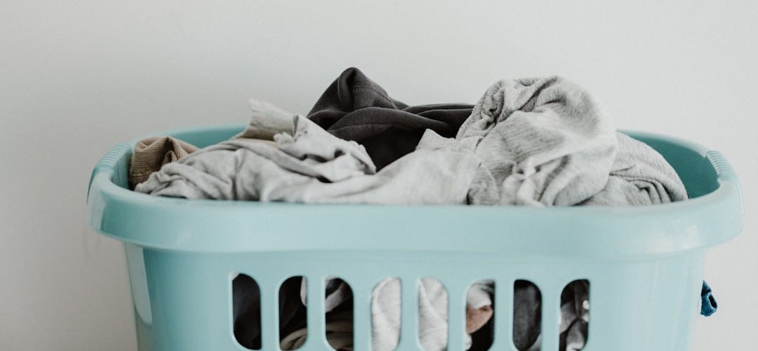 white textile on blue plastic laundry basket