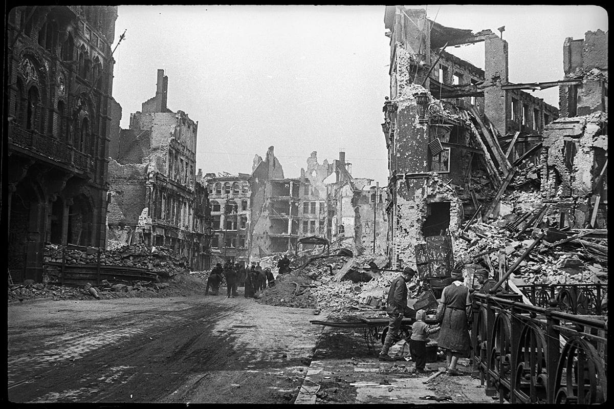 A group of people in a destroyed city

AI-generated content may be incorrect.