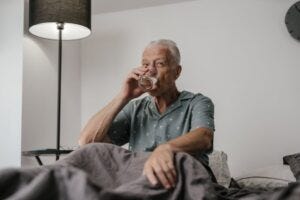 elderly man sitting up in bed