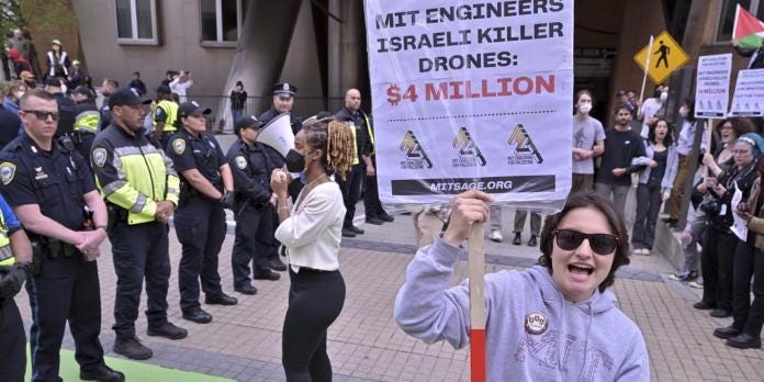 Pro-Palestinian demonstrators face of with a line of police outside the Stata Center at MIT, Thursday, May 9, 2024, in Cambridge, Mass. Police detained at least three members of a group of close to 100 demonstrators who held signs criticizing MIT for research they claim was being conducted for Israeli military drones. (AP Photo/Josh Reynolds)
