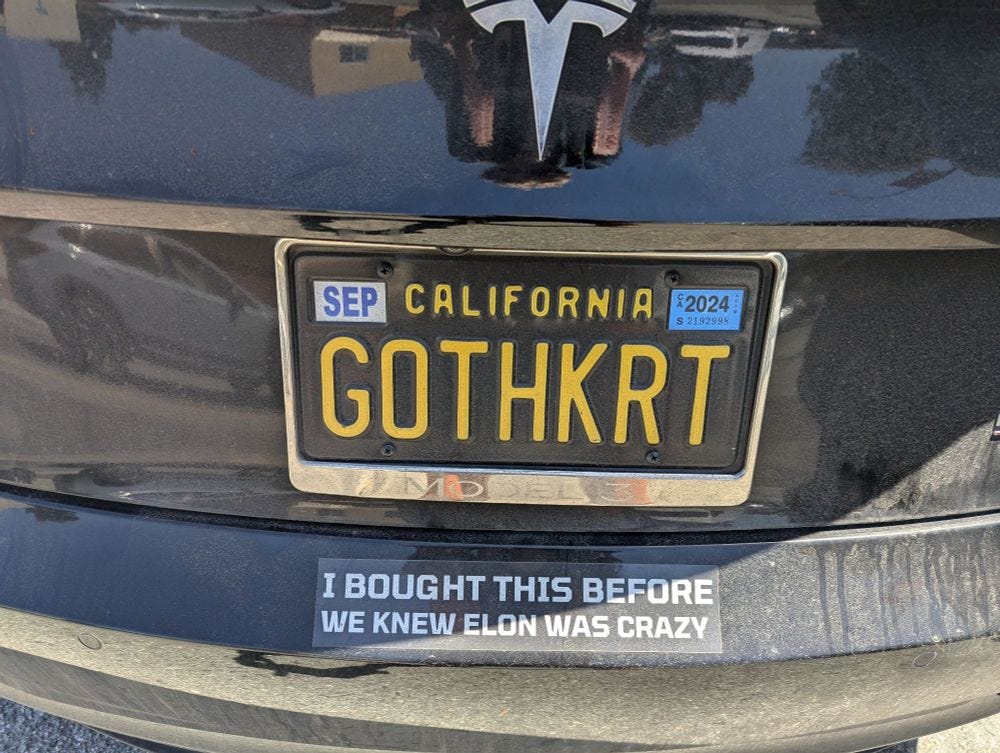 Bumper sticker on black Tesla — vanity plate GOTHKRT — reads "I bought this before we knew Elon was crazy." Bumper sticker on black Tesla — vanity plate GOTHKRT — reads "I bought this before we knew Elon was crazy."