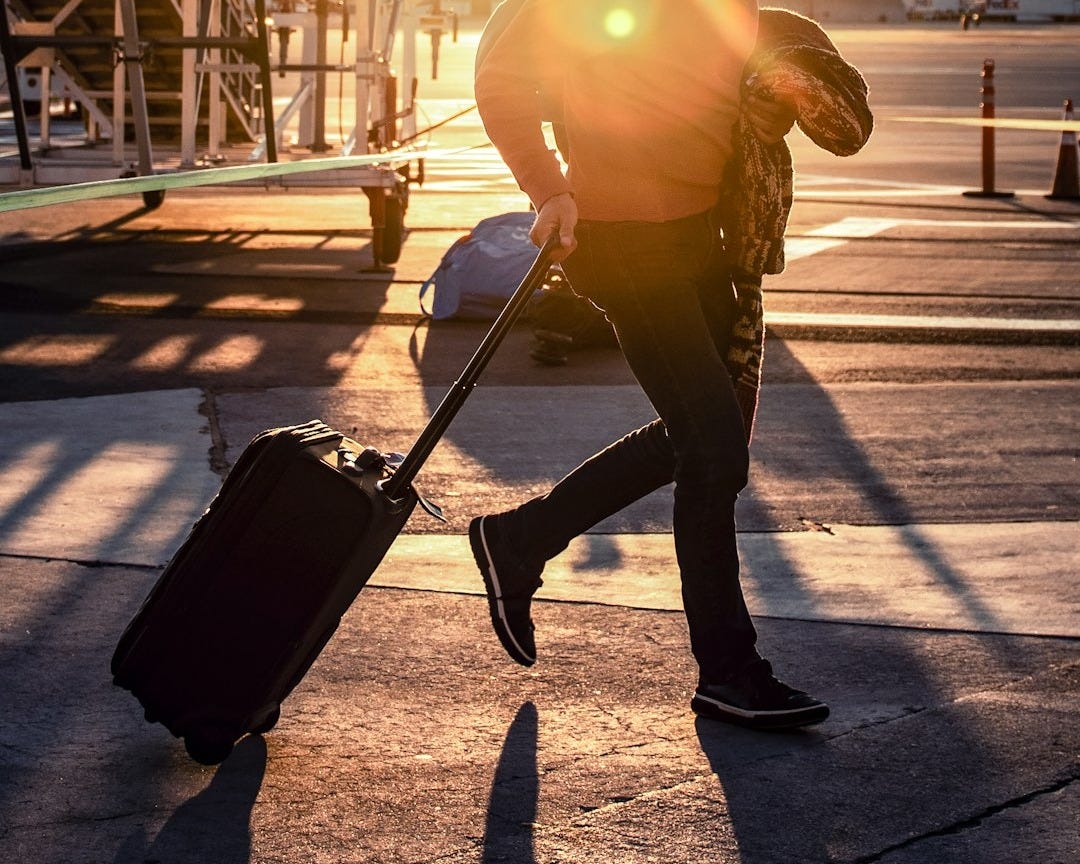 man walking with his black luggage bag man walking with his black luggage bag