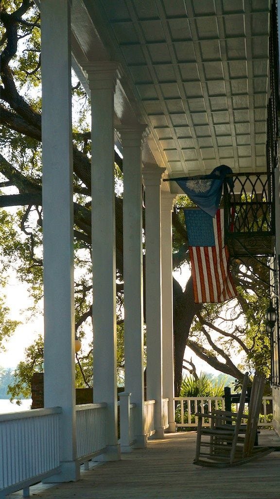 This may contain: an american flag hanging from the side of a porch