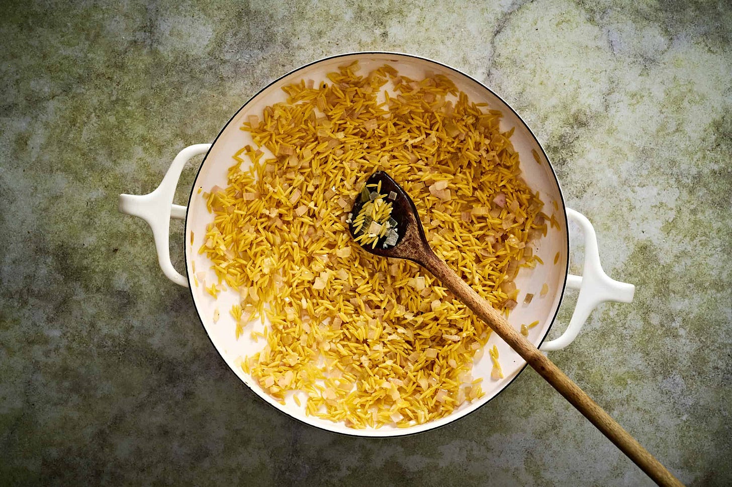 Simmering orzo in the chicken broth with lemon zest.