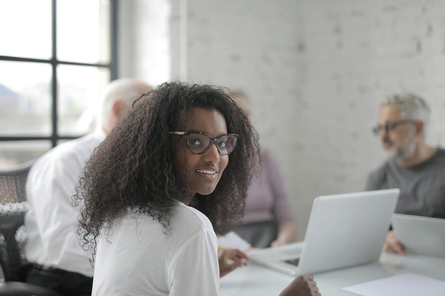 smiling female working in office with coworkers